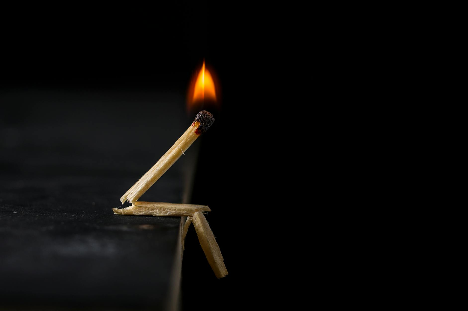 Artistic matchstick figure with a burning flame against a dark background, showing creativity.