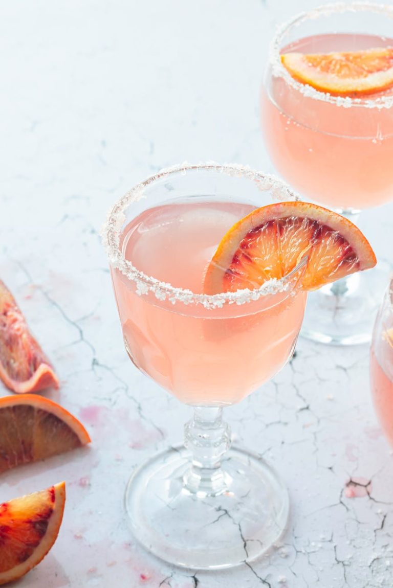 Refreshing blood orange cocktail with a salt rim, perfect for summer parties.