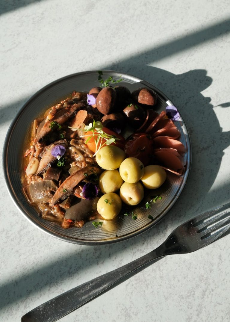 A Mediterranean dish with olives, mushrooms, and vegetables, photographed in natural light.