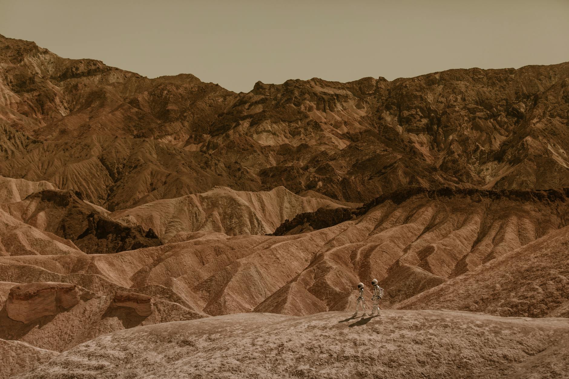 Astronauts exploring a stunning desert landscape, resembling Mars.