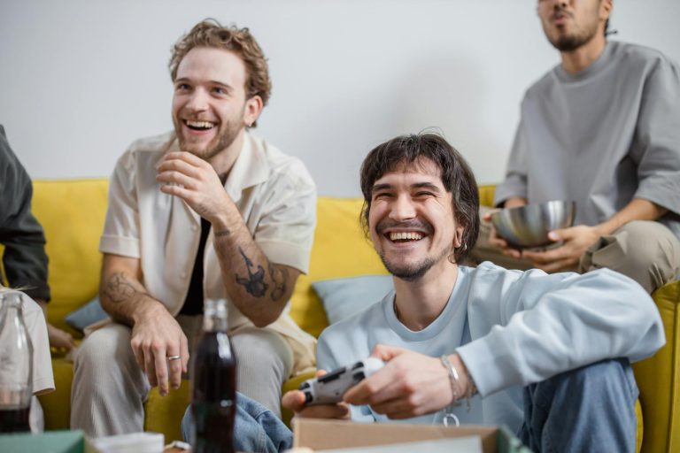 Group of friends laughing and enjoying video games together indoors.