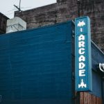 Blue urban building with retro arcade sign, showcasing vintage gaming style.