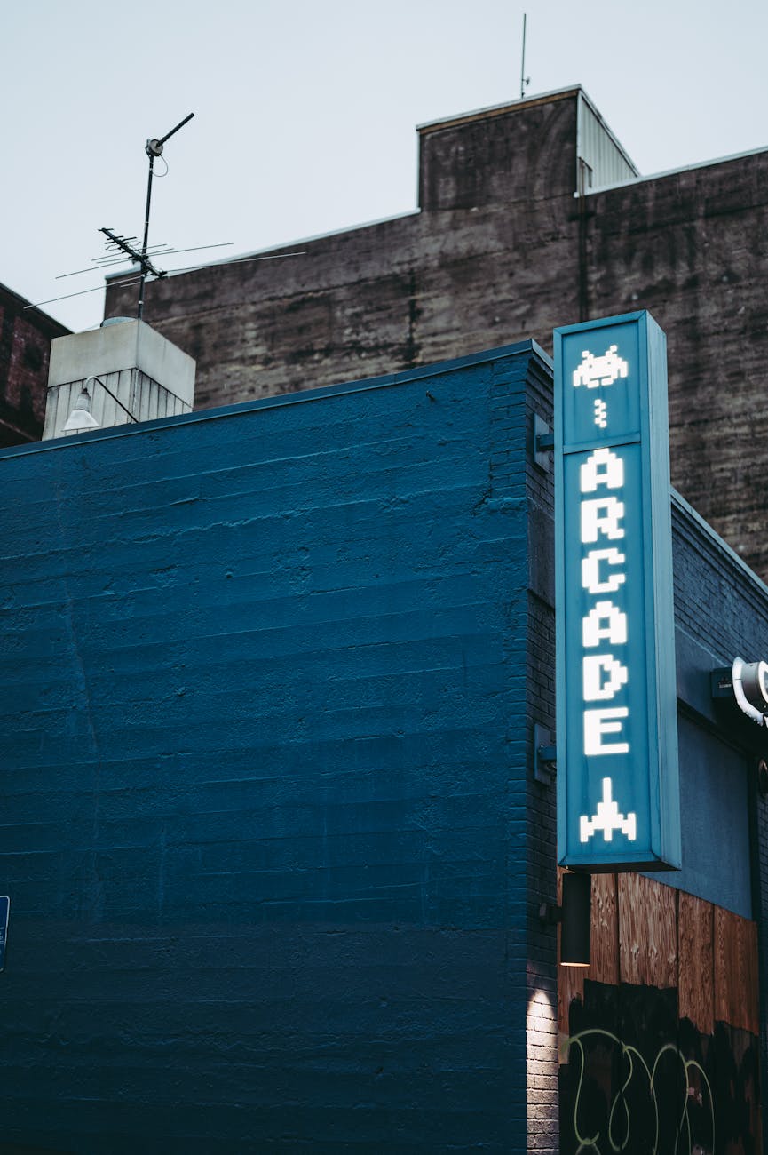 Blue urban building with retro arcade sign, showcasing vintage gaming style.