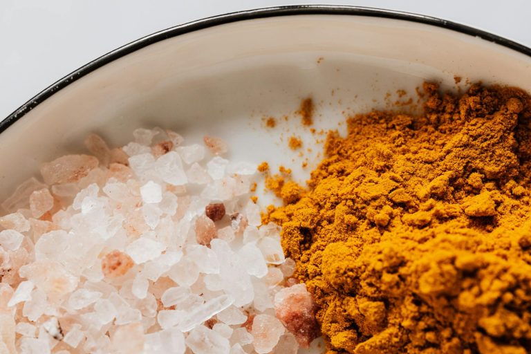 Close-up of pink Himalayan salt and turmeric powder creating a vibrant contrast.