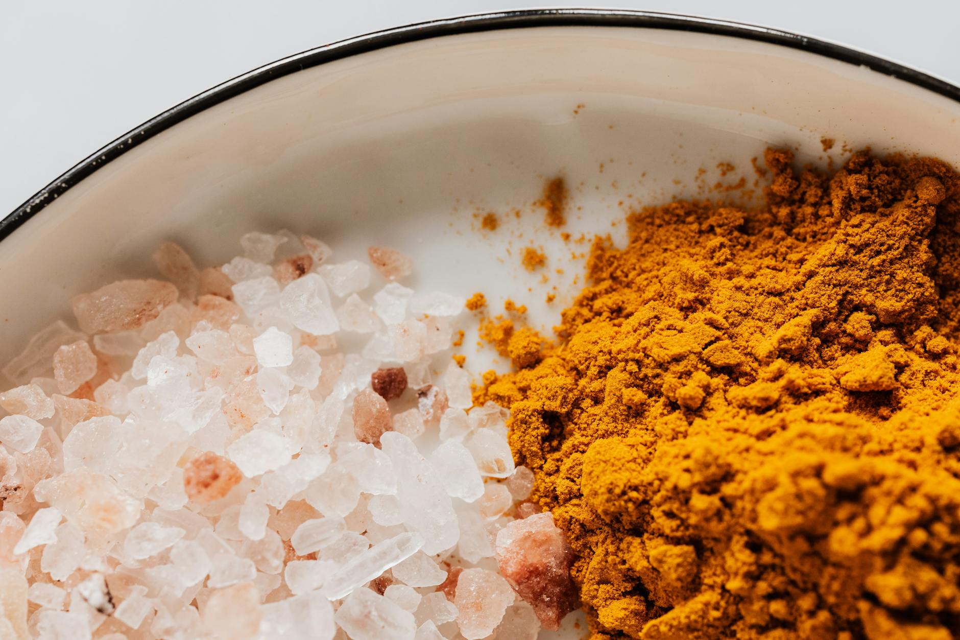 Close-up of pink Himalayan salt and turmeric powder creating a vibrant contrast.