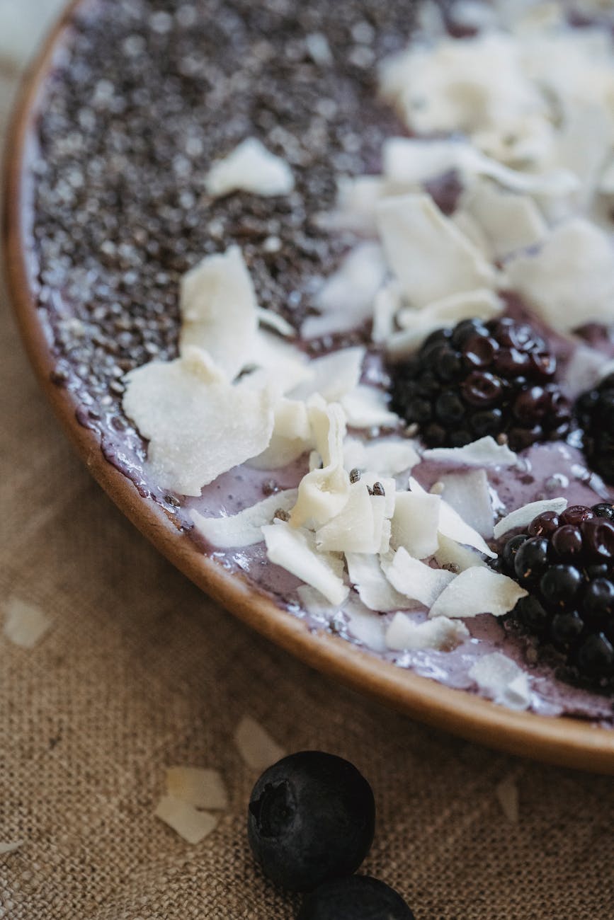 Close-up of a breakfast bowl with blackberries, blueberries, chia, and coconut shavings.