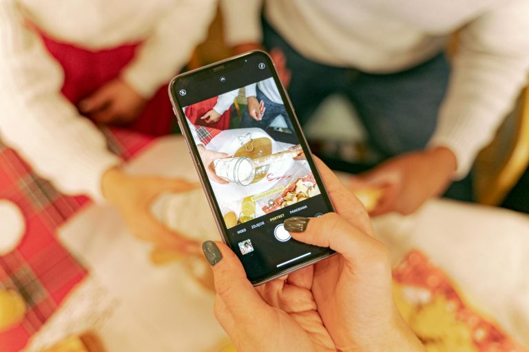 A person taking photos of a festive baking scene with a smartphone. Perfect for holiday baking themes.