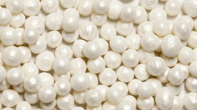 Detailed image of shiny white pearls, highlighting the texture and smooth surface for decorative use.