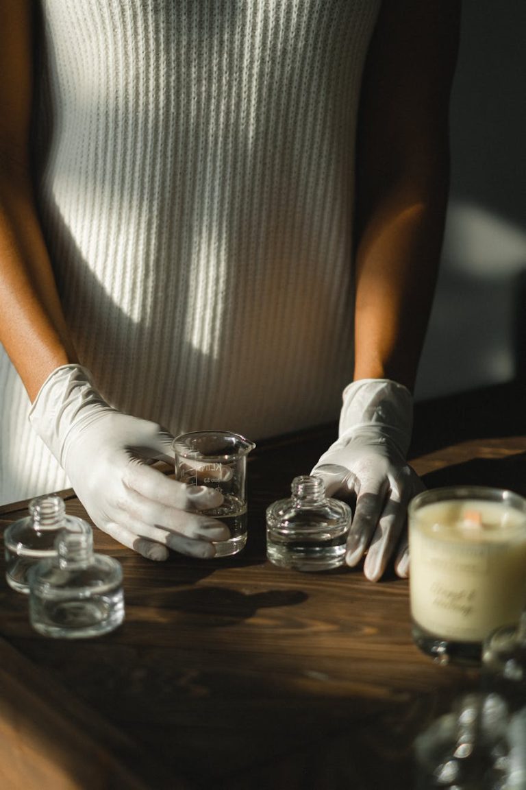 Aromatic essence preparation with gloved hands and glass jars indoors.