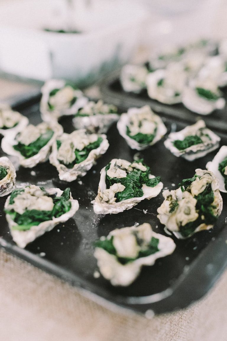 Close-up of Gourmet Oysters Rockefeller served with Spinach on baking tray.