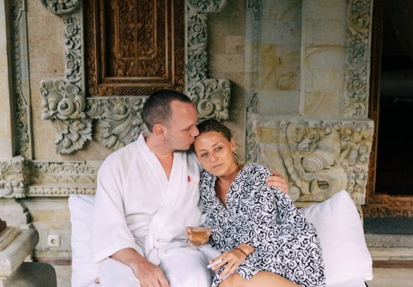 A couple relaxing in a spa setting with ornate decor, enjoying a peaceful time together.