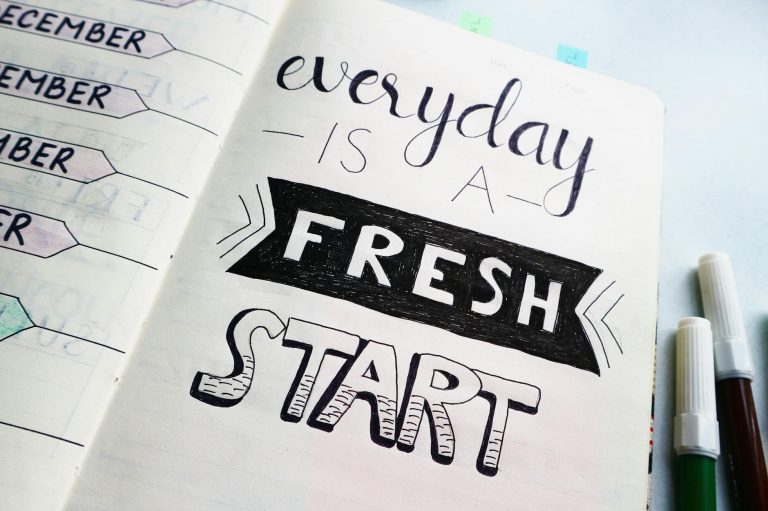Notebook page featuring motivational quote 'Everyday is a fresh start' with colorful pens.