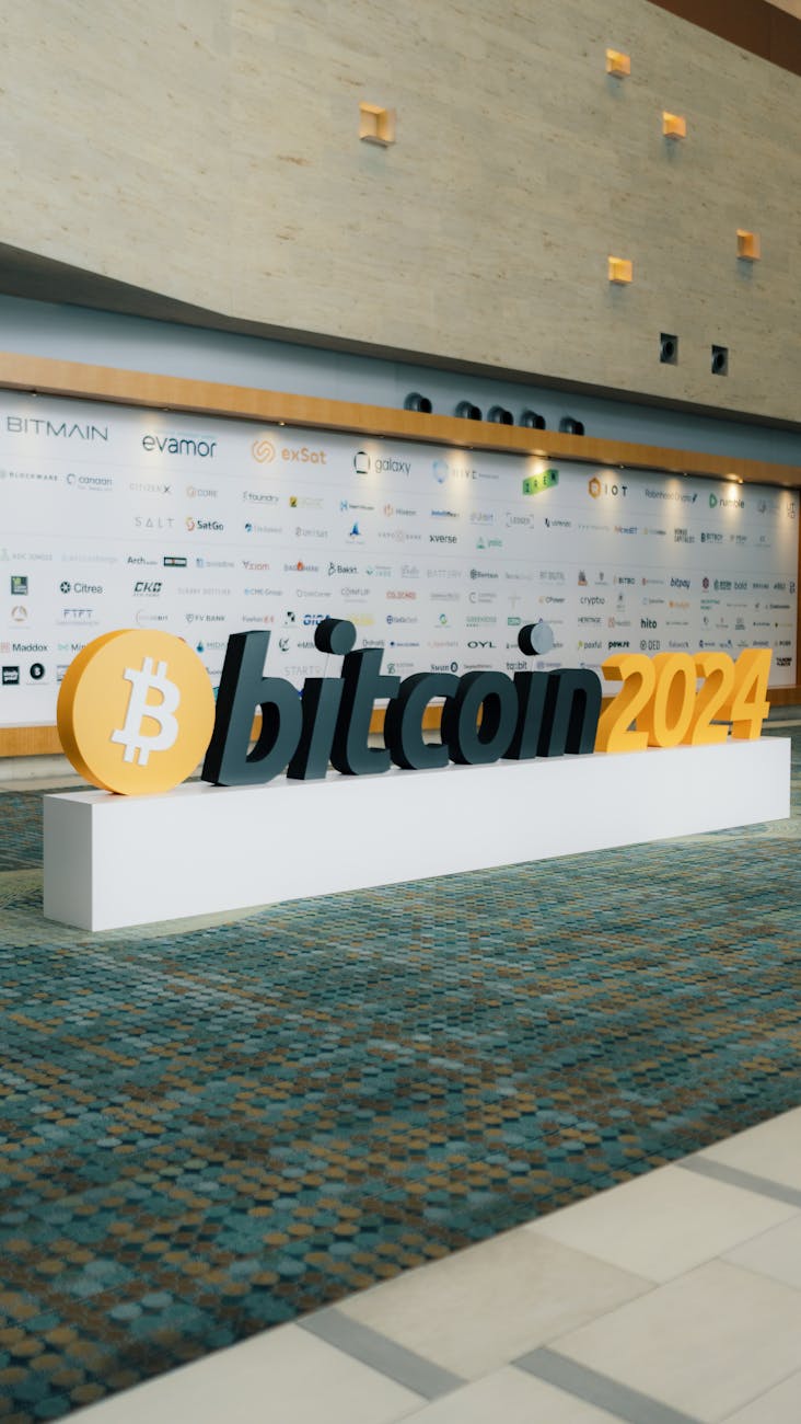 Modern entrance display for Bitcoin 2024 conference with sponsor logos in the background.
