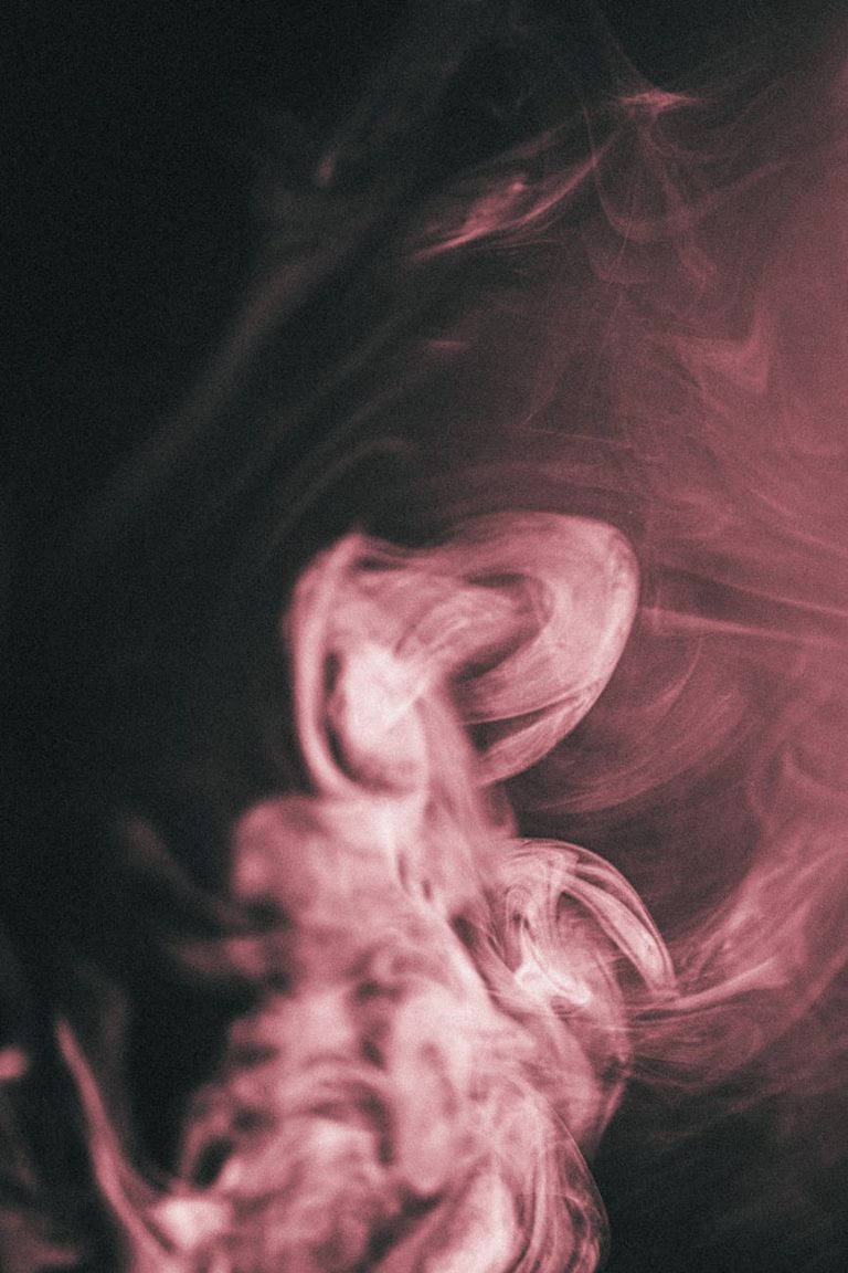 Abstract pink smoke swirling on a dark background, creating mystical patterns and textures.